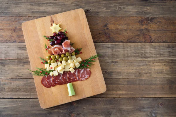 Noel ağacı şeklinde peynir ve ahşap tabanlı meze tahtası. Üst Manzara. Boşluğu kopyala.