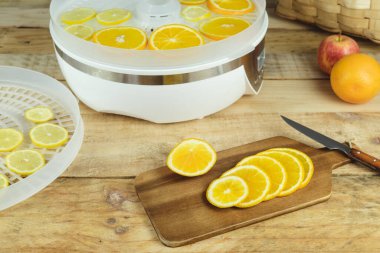 Mutfak masasında portakal dilimleri ile yiyecekleri kurutmak için ev yapımı makine..