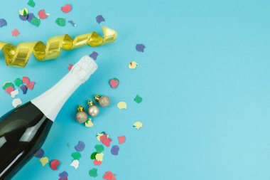 Yılbaşı arifesi dekorasyonlu şampanya şişesi mavi arka planda Noel konsepti. Boşluğu kopyala.