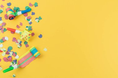 Yıl sonu için parti dekorasyonları ve sarı arka planda doğum günleri. Boşluğu kopyala.