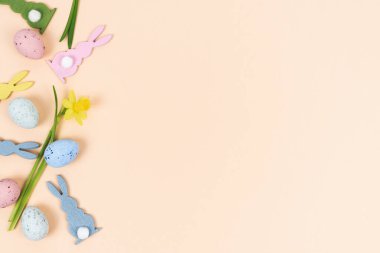 Tavşan figürlü ve sarı nergisli Paskalya yumurtaları. Sağ taraftaki boşluğu kopyala. Din kavramı.