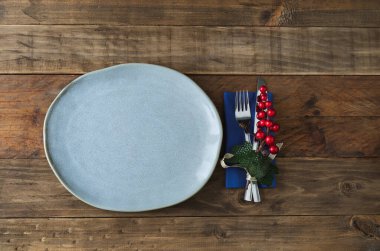 Ahşap arka planda, sağ tarafında Noel süslemesi olan köylü plakası. Boşluğu kopyala.