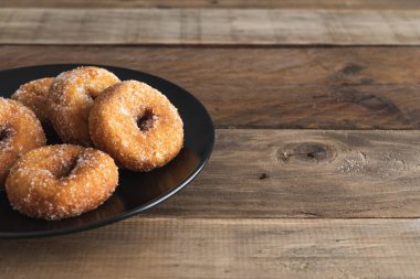 Tatlı çörekler, ahşap arka planda siyah tabakta karnaval tatlısı. Boşluğu kopyala.