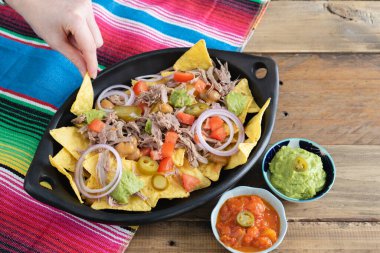 Et ve Meksika dekorasyonlu bir tepsi nacho. Salsa soslu kâseler. Üst Manzara. Uzayı kopyala Meksika mutfak konsepti.