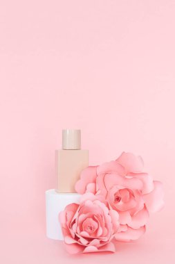 Şişeli yayalar ve pembe arka planda kağıt güller. Boşluğu kopyala.