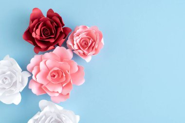 Mavi arka planda renkli kağıt güller. Uzayı kopyala Tebrik kartı. Anneler Günü. Sevgililer Günü.