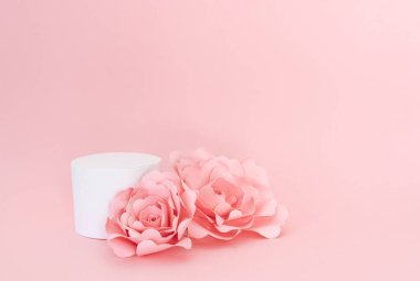 Pembe arka planda kağıt güller olan ürün sunumu için boş dairesel platform. Boşluğu kopyala.