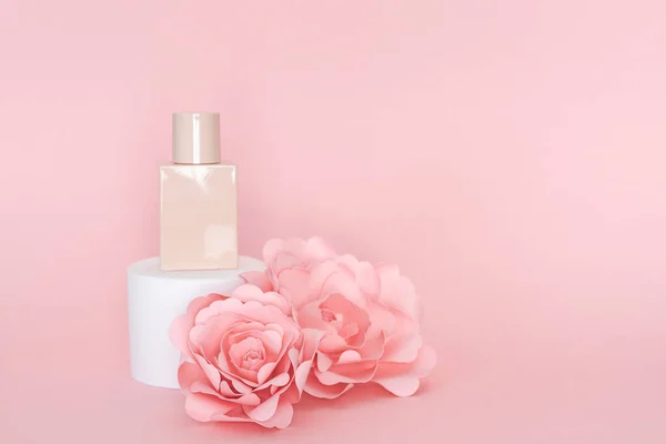 Sockel Mit Flasche Und Ornament Aus Papierrosen Auf Rosa Hintergrund — Stockfoto