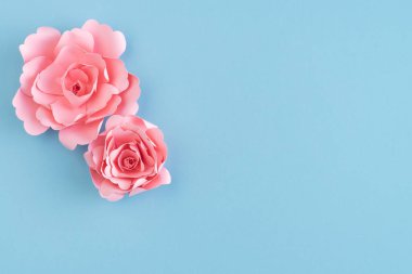 Mavi arka planda kağıt güller. Uzayı kopyala Tebrik kartı. Anneler Günü. Sevgililer Günü.