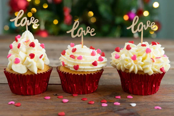 Tři Cupcakes Zdobené Dřevěném Pozadí Nápisem Love Rozostřené Vánoční Stromeček — Stock fotografie