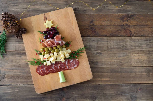 Noel ağacı şeklinde peynir ve ahşap tabanlı meze tahtası. Üst Manzara. Boşluğu kopyala.