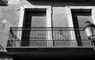 Paslı balkonu olan eski bir ev cephesi ve klasik sokak lambasının yanında kör. Roman köyü, Valencia topluluğu, İspanya.