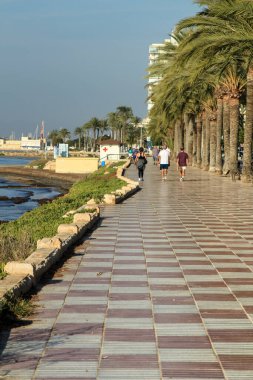 Santa Pola, Alicante, İspanya 'da güneşli bir sonbahar gününde kumsalın yanında güzel bir gezinti..