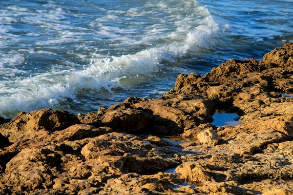 İspanya 'da dalgalar renkli kayaları vuruyor.