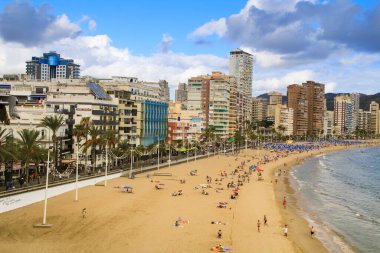 Benidorm, Alicante, İspanya - 9 Ekim 2021: İnsanlar Benidorm 'da güneşli bir sonbahar gününde Levante sahilinde güneşleniyorlar