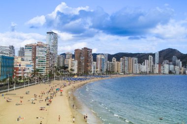 Benidorm, Alicante, İspanya - 9 Ekim 2021: İnsanlar Benidorm 'da güneşli bir sonbahar gününde Levante sahilinde güneşleniyorlar