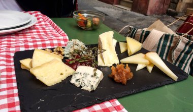 Farklı peynirler ve İberya jambonu olan restoran masası.