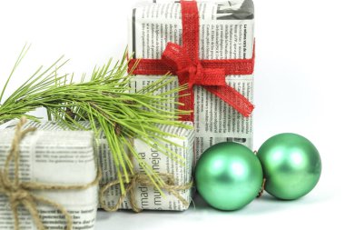 Alicante, İspanya - 18 Ekim 2020: Beyaz arka planda çam dalı, ip ve yeşil takılar ile eski gazetelere sarılı hediyeler