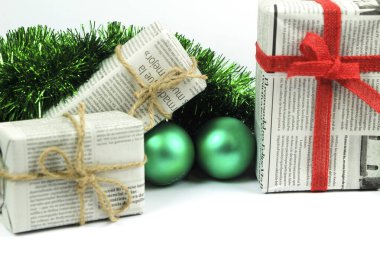 Alicante, İspanya - 18 Ekim 2020: Eski gazeteye sarılı hediyeler yeşil süs, ip ve yeşil takılar beyaz arka planda