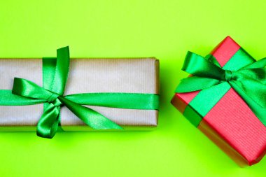 Renkli kağıda sarılı hediyeler ve yeşil arka planda yeşil ve siyah fiyonklar