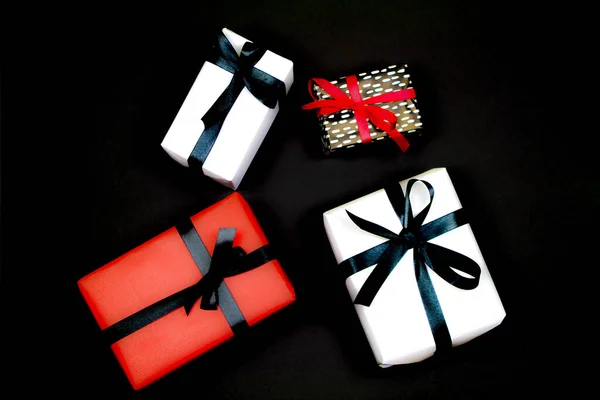 Подарки Обернутые Цветной Бумагой Красными Черными Бантами Черном Фоне — стоковое фото