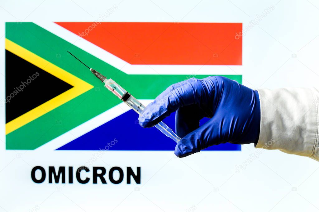Hand holding syringe with covid vaccine. South African flag and Omicron covid variant word written in the background