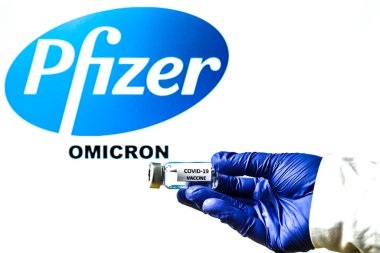 Madrid, İspanya - 29 Kasım 2021: Beyaz arka planda covid-19 aşısı ve Pfizer logosu olan el ele tutuşma şişesi.