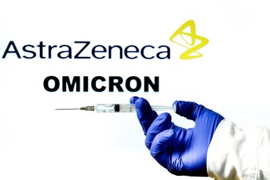 Madrid, İspanya - 29 Kasım 2021 Covid-19 aşısı, Astrazeneca logosu ve beyaz arka planda yazılmış New Variant Omicron kelimesiyle el ele tutuşma şırıngası.