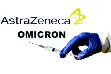 Madrid, İspanya - 29 Kasım 2021 Covid-19 aşısı, Astrazeneca logosu ve beyaz arka planda yazılmış New Variant Omicron kelimesiyle el ele tutuşma şırıngası.