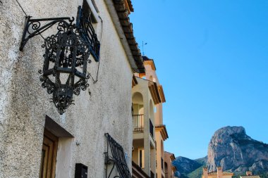 İspanya, Alicante 'deki Polop köyünde dövülmüş güzel bir metal fenerin cephesi. Arkaplanda Ponoig Dağı.