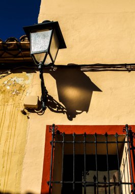 Valencia, İspanya 'daki Polop köyünün penceresinin yanında klasik sokak lambası olan eski bir ev cephesi..