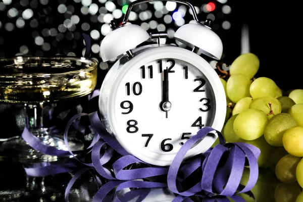 真夜中に新年 時計12時のブドウ 好意と背景に明るい休日の光の横にある — ストック写真