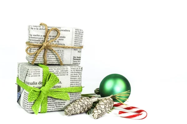 Madrid, İspanya - 17 Aralık 2021: Çam dallı eski gazetelere sarılı hediyeler, beyaz arka planda Noel tatlısı ve topu