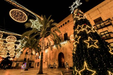 Elche, Alicante, İspanya... 20 Aralık 2021 'de insanlar Elche' nin aydınlatma ve Noel motifleriyle süslenmiş güzel sokaklarında eğlenip yürüyorlar.
