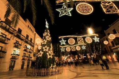 Elche, Alicante, İspanya... 20 Aralık 2021 'de insanlar Elche' nin aydınlatma ve Noel motifleriyle süslenmiş güzel sokaklarında eğlenip yürüyorlar.