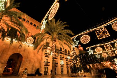 Elche, Alicante, İspanya... 20 Aralık 2021 'de insanlar Elche' nin aydınlatma ve Noel motifleriyle süslenmiş güzel sokaklarında eğlenip yürüyorlar.