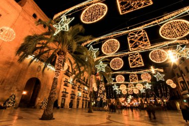 Elche, Alicante, İspanya... 20 Aralık 2021 'de insanlar Elche' nin aydınlatma ve Noel motifleriyle süslenmiş güzel sokaklarında eğlenip yürüyorlar.