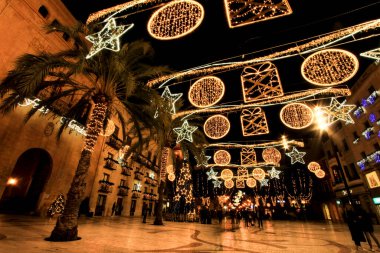 Elche, Alicante, İspanya... 20 Aralık 2021 'de insanlar Elche' nin aydınlatma ve Noel motifleriyle süslenmiş güzel sokaklarında eğlenip yürüyorlar.