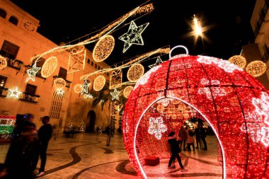 Elche, Alicante, İspanya... 20 Aralık 2021 'de insanlar Elche' nin aydınlatma ve Noel motifleriyle süslenmiş güzel sokaklarında eğlenip yürüyorlar.