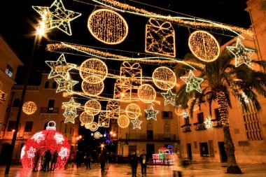 Elche, Alicante, İspanya... 20 Aralık 2021 'de insanlar Elche' nin aydınlatma ve Noel motifleriyle süslenmiş güzel sokaklarında eğlenip yürüyorlar.