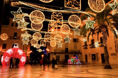 Elche, Alicante, İspanya... 20 Aralık 2021 'de insanlar Elche' nin aydınlatma ve Noel motifleriyle süslenmiş güzel sokaklarında eğlenip yürüyorlar.