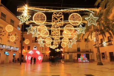 Elche, Alicante, İspanya... 20 Aralık 2021 'de insanlar Elche' nin aydınlatma ve Noel motifleriyle süslenmiş güzel sokaklarında eğlenip yürüyorlar.