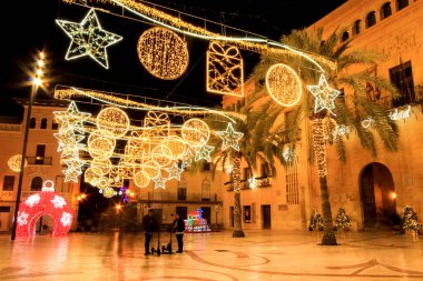 Elche, Alicante, İspanya... 20 Aralık 2021 'de insanlar Elche' nin aydınlatma ve Noel motifleriyle süslenmiş güzel sokaklarında eğlenip yürüyorlar.