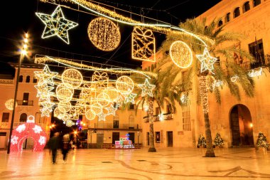 Elche, Alicante, İspanya... 20 Aralık 2021 'de insanlar Elche' nin aydınlatma ve Noel motifleriyle süslenmiş güzel sokaklarında eğlenip yürüyorlar.