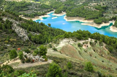 Güneşli bir günde çevresi bitki ve dağlarla çevrili Guadalest köyünün bataklığı.