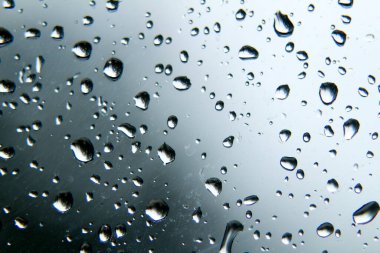 Soğuk ve bulutlu bir kış gününde pencere camında yağmur damlaları