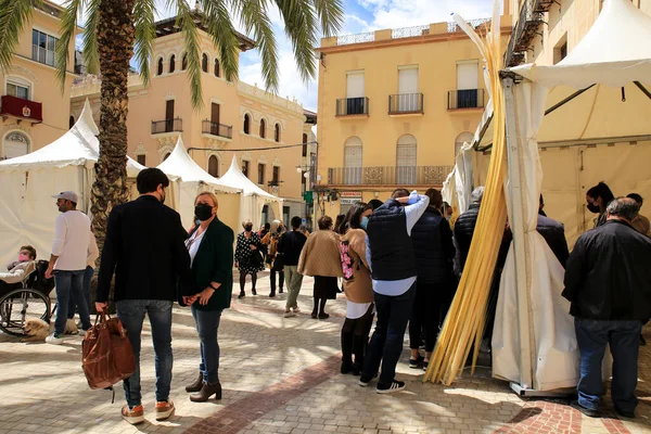 Elche, Alicante, İspanya... 9 Nisan 2021: insanlar Elche 'deki Palm Sunday geçit töreni için beyaz palmiye satın alıyorlar.