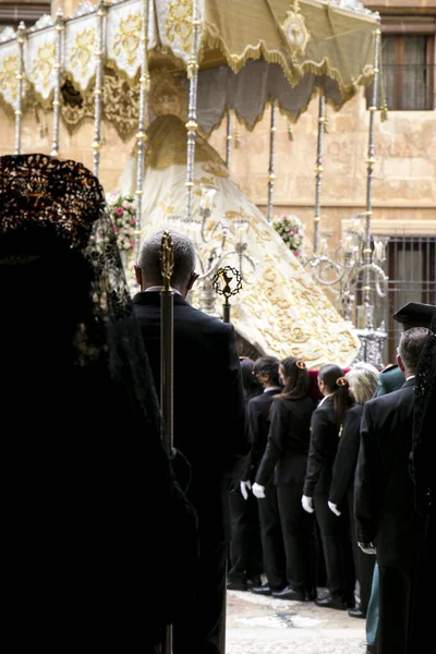 Elche, İspanya - 13 Nisan 2022: Paskalya Geçidi 'nde Santa Maria kilisesinden dışarı çıkan mantilla elbiseleri giyen kadınlar ve hamileler ile Bakire Meryem.