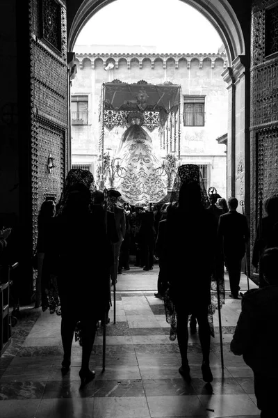 Elche, İspanya - 13 Nisan 2022: Paskalya Geçidi 'nde Santa Maria kilisesinden dışarı çıkan mantilla elbiseleri giyen kadınlar ve hamileler ile Bakire Meryem.