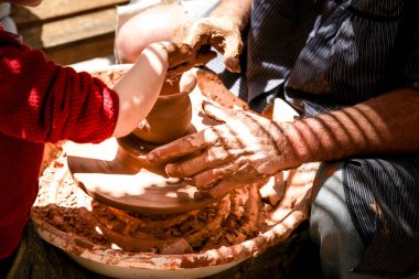 Finestrat, Alicante, İspanya... 23 Nisan 2022: Baba oğluna Gastronomik ve Geleneksel Finestrat Pazarı 'nda çömlekçi ticareti öğretiyor.